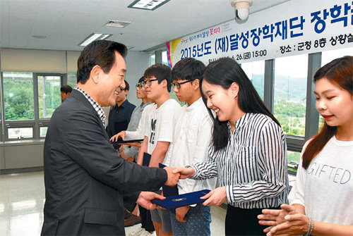 대구 달성군에서 열린 장학금 수여식에서 김문오 군수(왼쪽)가 학생에게 장학증서를 전달하고 있다. 대구 달성군 제공