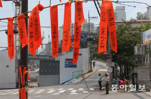 14일 서울 성북구 동신초등학교 앞 횡단보도에서 수업을 마친 학생들이 길을 건너려고 기다리고 있다. 공사 차량이 수시로 오가지만 안전대책이 없어 학부모와 아이들은 항의 표시로 교문 앞 나무에 빨간색 리본을 걸어 놨다. 홍진환 기자 jean@donga.com