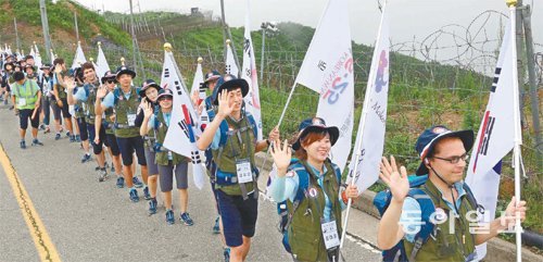 21일 ‘제2회 대학생 동부전선 DMZ 통일발걸음’에 참가한 대학생들이 태극기를 든 채 강원 양구군 을지전망대 철책길을 걷고 있다. 사단법인 물망초가 주최하고 동아일보가 후원한 이 행사에는 남한 출신은 물론이고 탈북민, 외국인 대학생도 동참했다. 양구=김미옥 기자 salt@donga.com