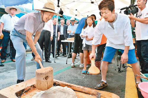 밀짚모자 쓰고 ‘떡메 치기’ 허창수 전국경제인연합회 회장(왼쪽)이 22일 강원 평창군 봉평 5일장을 방문해 현지에서 구입한 밀짚모자를 쓰고 떡메 치기를 체험하고 있다. 전국경제인연합회 제공