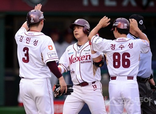 넥센 윤석민(가운데)이 26일 목동 SK전 1회말 1사 1·3루서 좌중월3점홈런을 날리고 홈으로 들어와 정수성 1루 코치, 선행주자 김민성의 축하를 받고 있다. 윤석민은 이 한방으로 2년 연속 두 자릿수 홈런을 달성했다. 목동｜김종원 기자 won@donga.com