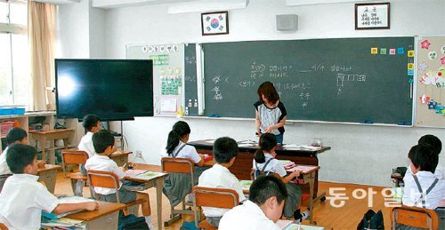 지난달 중순 오사카 외곽의 민단계 학교인 금강학교의 한 교실에서 학생들이 한국어 수업을 받고 있다. 벽에 걸린 태극기와 '나라를 사랑하자는 교훈이 눈에 띈다. 이 학교의 법적 지위는 일본 교육당국의 지원과 관리감독을 받는 이른바 '일보 학교'이다. 중학교까지 무상교육인 일본학교와 달리 수업료를 내고 교통도 불편하지만 학부모와 학생들은 '민족 교육'을 위해 이 모두를 감수하고 있다. 오사카=조숭호 기자 shcho@donga.com