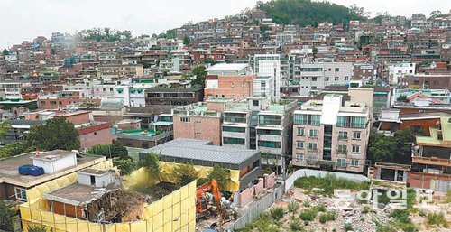 지난달 말 서울 성북구 장위동에서 낡은 주택을 허무는 공사(왼쪽 아래 노란색 가림막 안)가 한창이다. 뉴타운 해제 지역 중 유일하게 도시 재생 시범구역에 지정된 장위동에선 최근 다가구 다세대주택 건축이 늘고 있다.