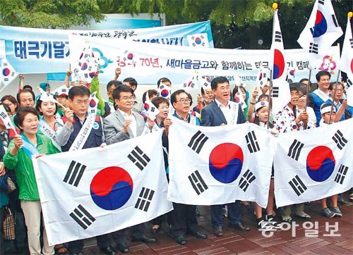 “태극기를 다세요” 광복 70주년을 앞두고 12일 부산시청 녹음광장에서 새마을단체와 새마을금고, 시 직원 등 300여 명이 참여해 ‘전국 동시 태극기 달기 운동 캠페인’을 개최했다. 서영수 기자 kuki@donga.com