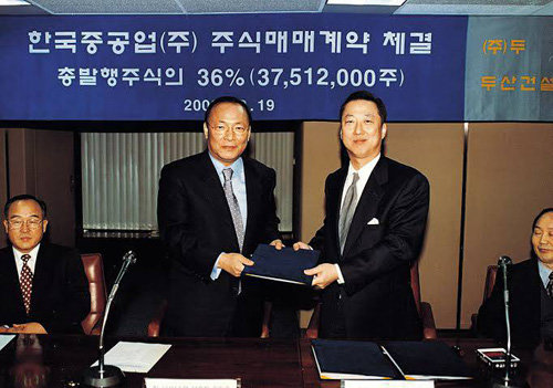 2001년 한국중공업 지분 인수 계약을 마치고 박용만 당시 ㈜두산 전략기획본부 사장(오른쪽)이 기념촬영을 하고 있다. 두산그룹 제공
