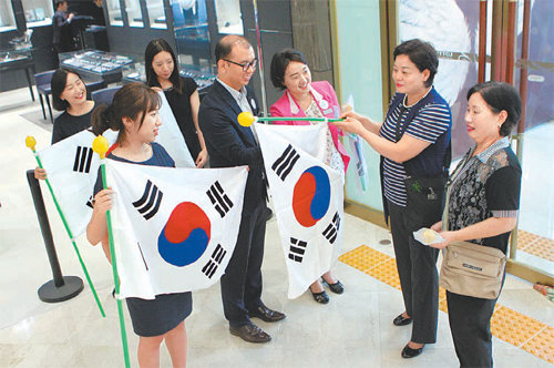 13일 롯데백화점 광주점 직원들이 개점과 동시에 입장한 고객들에게 가정용 태극기를 건네고 있다. 롯데백화점 광주점 제공