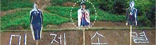 북한 조선중앙TV가 12일 북한군이 박근혜 대통령의 사진을 붙인 표적(점선 안)을 향해 사격 연습을 하는 영상을 내보내고 있다. 공개된 표적 뒤에는 ‘미제소멸’이라는 글자가 쓰여 있다. 조선중앙TV 화면 캡처