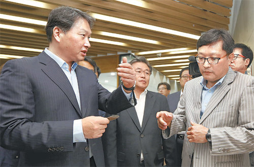 최태원 SK그룹 회장(왼쪽)이 18일 대전창조경제혁신센터에서 이경수 테그웨이 대표(오른쪽)로부터 구부러지는 열전소자에 대한 설명을 듣고 있다. SK그룹 제공
