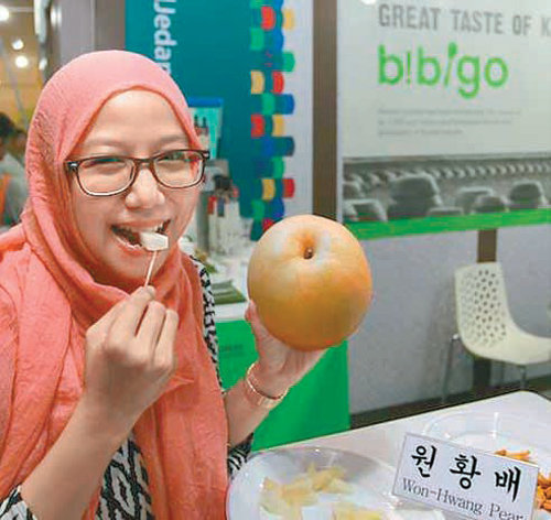 14일 말레이시아 쿠알라룸푸르에서 열린 K푸드 페어 행사장에서 아젤리아 파라미타 씨(30)가 한국 토종인 원황배를 맛보고 있다. 한국농수산식품유통공사 제공