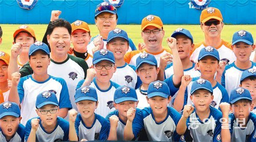 ‘한국야구의 전설’ 선동열 전 KIA 감독(맨 뒷줄 왼쪽)과 김시진 전 롯데 감독(맨 뒷줄 오른쪽), 이만수 전 SK 감독(앞에서 세 번째 줄 왼쪽)이 19일 경기 연천군 베이스볼파크에서 열린 ‘2015 KBO 유소년 야구캠프’에서 꿈나무 야구선수들과 함께 파이팅을 외치고 있다. 연천=홍진환 기자 jean@donga.com