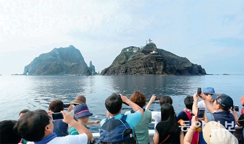 독도를 떠나는 관광객들이 휴대전화로 독도의 모습을 담고 있다. 파도치는 독도에서의 머묾은 짧지만 강렬한 인상을 남겼다. 많은 이가 독도에 도착하기 직전부터 눈물을 흘렸다. 독도=신원건 기자 laputa@donga.com