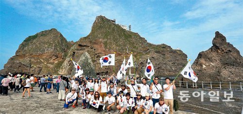 독도에 도착한 관광객들이 태극기를 들고 기념사진을 찍고 있다. 날씨 등의 변수 때문에 언제나 독도에 내릴 수 있는 것은 아니어서 ‘독도에 내리려면 3대가 덕을 쌓아야 한다’는 말도 있다. 독도=신원건 기자 laputa@donga.com