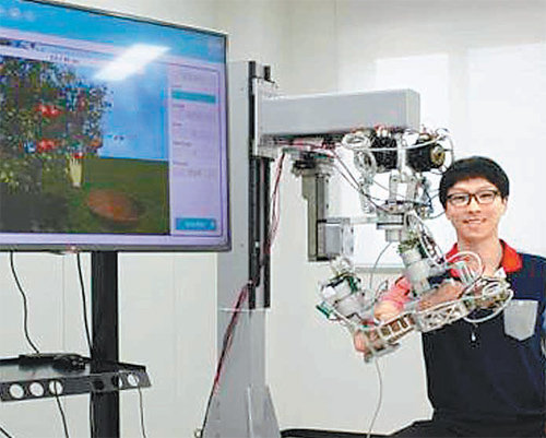 한국기계연구원이 최근 개발한 재활로봇. 로봇 팔을 착용하고 화면으로 ‘사과 따기’ 게임을 하면서 팔의 기능을 되찾을 수 있도록 돕는다. 한국기계연구원 제공