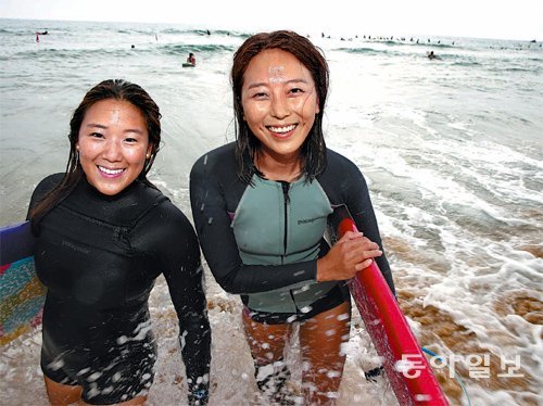 김수영 씨(왼쪽)와 박보현 씨가 16일 강원 양양 죽도해변에서 서핑을 즐기며 환하게 웃고 있다. 김 씨와 박 씨는 2년 전만 해도 전혀 알지 못하는 사이였지만 서핑을 하다 친해져 친자매처럼 지내는 사이가 됐다. 두 명은 사진을 찍는 중에도 “지금 파도가 좋아 빨리 타러 가야 한다”고 말했다. 양양=김경제 기자 kjk5873@donga.com