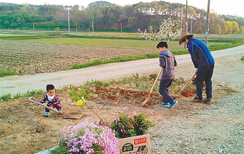 도심에서 직장생활을 접고 3년 전 충남 홍성군 홍동면으로 귀농한 이상철 씨가 자녀들과 함께 집앞 텃밭에 꽃을 심고 있다. 홍성군 제공