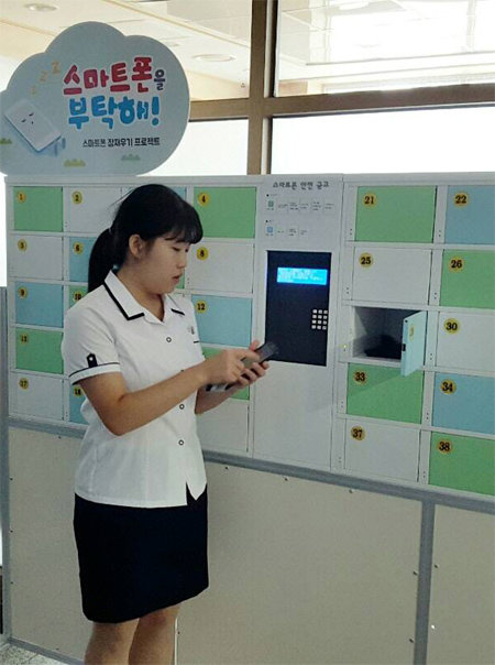 ‘스마트폰 안전금고’ 특허권을 가진 수원하이텍고 2학년 박희라 양이 자신의 스마트폰을 금고에 넣고 있다. 한국생산기술연구원 제공