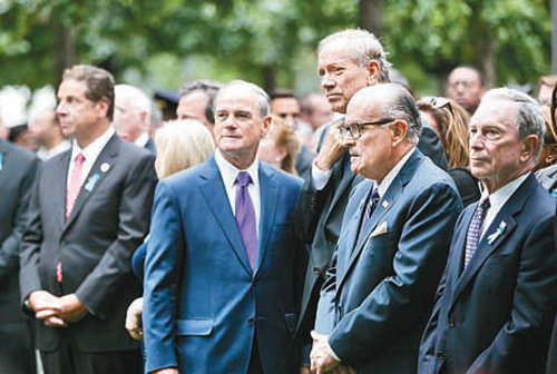 9·11테러 14주년 추모식에서 서서 추모식을 지켜보는 정치인들. 앤드루 쿠오모 뉴욕 주지사(왼쪽), 마이클 블룸버그와 루돌프 줄리아니 전 뉴욕 시장(오른쪽부터). 국립9·11메모리얼박물관 제공
