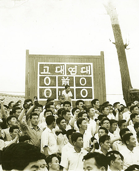 1950년대 서울운동장에서 열린 축구 고연전에서 학생들이 경기를 지켜보고 있다. 두 학교의 축구 대결은 1927년부터 시작됐다. 손으로 쓴 스코어보드가 이채롭다. 고려대 제공·동아일보DB