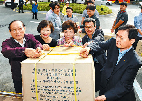 16일 대구 남구청 광장에서 열린 몽골 사랑의 옷 보내기 행사에 참석한 임병헌 구청장(왼쪽)과 직원들이 의류가 담긴 상자를 트럭에 싣고 있다. 대구 남구 제공