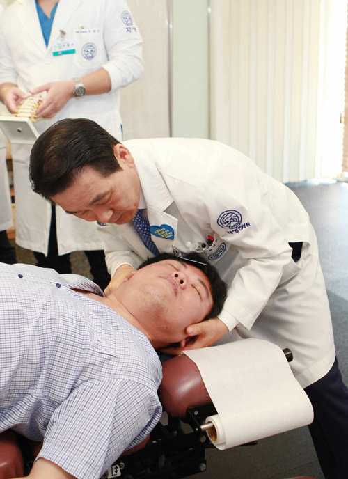 박병모 자생한방병원 병원장이 목 디스크 환자에게 추나요법을 실시하고 있다.