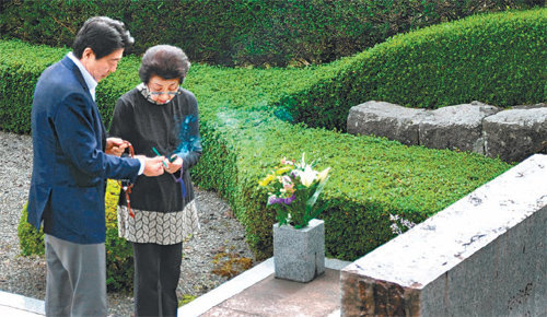 아베 신조 일본 총리(왼쪽)가 22일 어머니 요코 여사와 함께 시즈오카 현 오야마 정의 후지묘원을 찾아가 외조부 기시 노부스케 전 총리의 영전에 참배하고 있다. 아베 총리는 이날 참배에서 안보법제 통과를 보고했다고 기자들에게 밝혔다. 아사히신문 제공