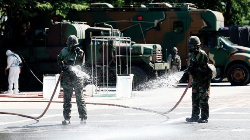 8월 18일 국군화생방방호사령부 소속 방역요원들이 서울 서초구청 광장에서 열린 ‘전시 감염병 테러 대비 훈련’에서 살포된 오염물질 구간을 소독하고 있다.