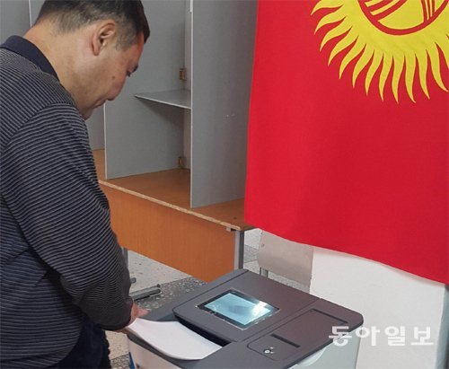 4일(현지 시간) 열린 키르기스스탄 총선에서 비슈케크 시 투표소를 찾은 한 유권자가 광학판독개표기(PCOS)에 투표용지를 넣고 있다. 비슈케크=한상준 기자 alwaysj@donga.com