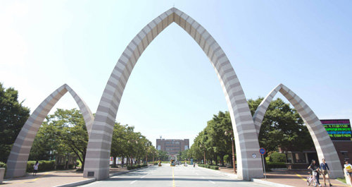 중앙도서관이 보이는 경상대 정문. 학문적 성취 및 행태 패턴(Behavior Pattern)과 높은 곳을 지향하려는 의지의 표현으로 ‘비상’을 뜻한다. 경상대 제공