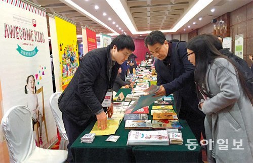 21일 오전 중국 지린 성 창춘 시에서 열린 ‘찾아가는 중국도서전’에 참가한 손정환 어썸키즈 출판사 대표(왼쪽)가 중국 출판사 관계자와 책 수출을 상담하고 있다. 창춘=민병선 기자 bluedot@donga.com