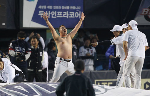 두산 유희관이 31일 잠실구장에서 한국시리즈 우승이 확정된 뒤 김현수가 팬들에게 약속한대로 상의를 탈의한 채 막춤을 추고 있다. 가슴에 붙인 밴드는 자신의 몸매를 의식한 ‘자체 심의’였다. 사진제공｜스포츠코리아