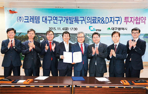 6일 대구시청에서 김호연 크레템 대표(왼쪽에서 네 번째)와 김연창 대구시 경제부시장(왼쪽에서 다섯 번째)이 투자 협약을 체결한 뒤 협약서를 들어보이고 있다. 대구시 제공