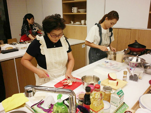 현대백화점이 판교점에서 개최한 요리 경연 대회에서 대상을 수상한 문보영(앞줄 왼쪽), 이지윤 씨 모녀가 ‘가을사과 담은 두부도넛’을 만들고 있다. 현대백화점 제공