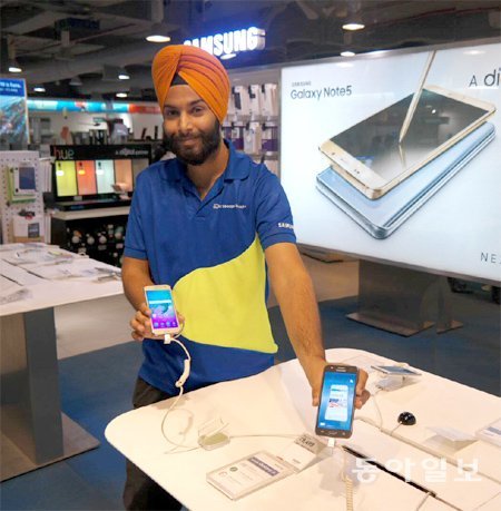 3일(현지 시간) 인도 뉴델리 전자매장에서 삼성전자 스마트폰 판매원이 갤럭시J2 등 인도 전용 스마트폰을 들어 보이고 있다. 뉴델리=김지현 기자 jhk85@donga.com