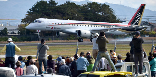 53년 만의 이륙 11일 오전 일본 나고야 공항에서 미쓰비시항공기의 신형 제트기 MRJ가 이륙을 위해 활주로에 서자 관람객들이 일어나 사진을 찍고 있다. 일본산 민간여객기가 시험비행을 한 것은 53년 만이다. 아사히신문 제공