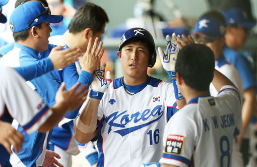 황재균(가운데)이 12일 대만 타오위안구장에서 열린 ‘2015 WBSC 프리미어 12’ 베네수엘라전 5회말 1사 후 좌월솔로홈런을 때린 뒤 덕아웃으로 돌아와 동료들과 하이파이브를 나누고 있다. 황재균은 연타석 홈런을 포함해 4타수 4안타 3타점의 맹타를 휘두르며 한국의 13-2, 7회 콜드게임 승리를 이끌었다. 사진제공｜스포츠코리아