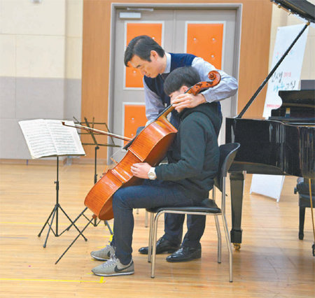 양성원 연세대 음대 교수가 인생나눔교실 참가 학생에게 첼로를 체험하도록 도와주고 있다. 문화예술위원회 제공