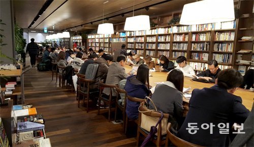 25일 서울 교보문고 광화문점을 찾은 독자들이 대형 독서 테이블에서 책을 읽고 있다. 김윤종 기자 zozo@donga.com