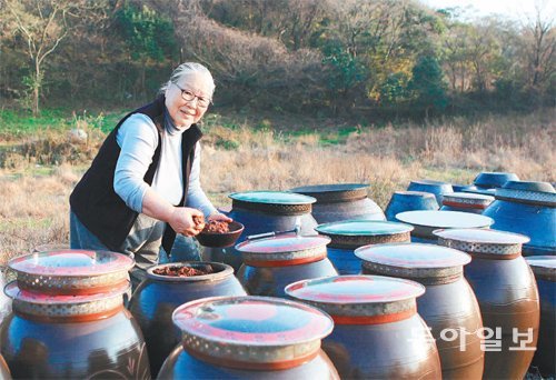 약선요리연구가 최순남 씨가 산나물이 가득한 ‘산에 사네’ 농장의 장독대에서 구수한 향기가 일품인 된장을 꺼내고 있다. 임재영 기자 jy788@donga.com