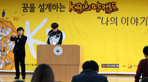 KB희망캠프에 참가한 한 장애청소년(가운데)이 지난달 서울 여의도 이룸센터에서 열린 꿈발표회에서 진로계획을 발표하고 있다. KB금융지주 제공