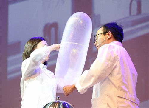 19금(禁) 과학콘서트 SNL 공연에서 이상곤 중앙대 약대 연구원(오른쪽)이 콘돔에 바람을 불어넣으며 최대로 버틸 수 있는 부피를 실험하고 있다. 한국과학창의재단 제공