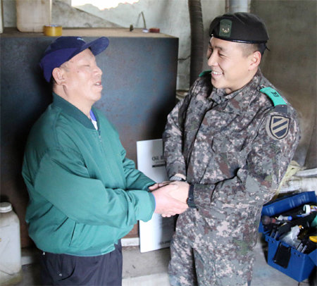 육군 제11기계화보병사단 천마대대 박삼영 중사(오른쪽)가 시각장애인 집의 보일러를 수리해 준 뒤 위로하고 있다. 육군 제공