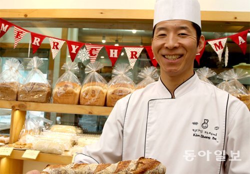 서울 마포구에서 ‘키다리 아저씨’ 빵집을 운영하며 지역사회 기부활동을 이어가고 있는 김생수 씨가 15일 오후 빵을 들고 활짝 웃고 있다. 김경제 기자 kjk5873@donga.com