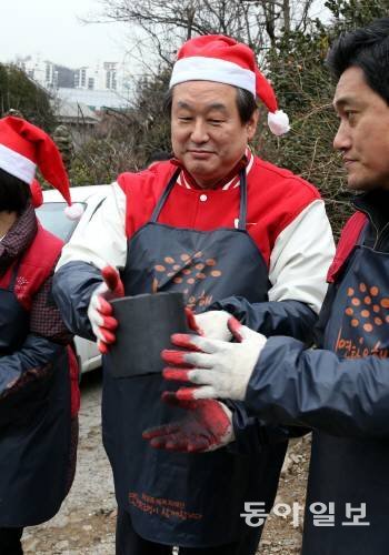 18일 김무성 새누리당 대표가 서울 관악구 삼성동에서 산타 복장을 하고 외국인 유학생들과 연탄배달 봉사에서 연탄을 나르고 있다. 김경제 기자 kjk5873@donga.com