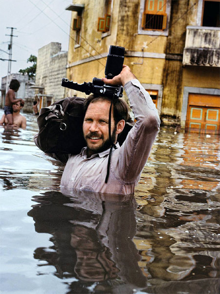 1983년 홍수가 난 인도 서부 포르반다르 지역에서 활약하는 스티브 맥커리. 그는 피사체에 가깝게 갈수록 좋은 사진을 찍을 수 있다고 말한다. 그는 생생한 보도 사진을 얻기 위해 언제나 위험한 현장에 한발 더 가까이 다가섰다. ⓒSteve McCurry/Magnum Photos