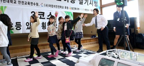 23일 경기 부천동초등학교에서 처음 열린 ‘제1회 보행자 면허증 실기시험’에 참가한 초등학생들이 왼팔을 대각선으로 들고 횡단보도를
 건너고 있다. 이날 70점 이상을 받아 시험을 통과한 학생들에게는 보행자 면허증이 발급됐다. 김재명 기자 
base@donga.com
