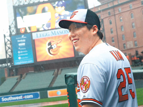 김현수가 등번호 25번이 새겨진 유니폼을 입고 볼티모어의 안방 구장인 메릴랜드 주 볼티모어의 오리올 파크에서 웃고 있다. 김현수는 두산에서 50번을 달았지만 투수 미겔 곤살레스가 50번을 쓰고 있어 새 번호를 받았다. 댄 듀켓 볼티모어 부사장은 24일 김현수와의 계약을 발표한 뒤 “김현수의 닉네임은 ‘아이언맨’이다. 볼티모어 프랜차이즈 칼 립켄과 닮았다”고 말했다. 볼티모어 제공