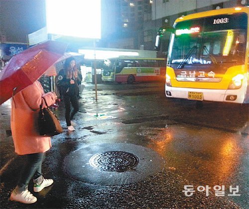 대전유성시외버스정류소가 지정좌석제나 순번제를 시행하지 않아 승객들이 비가 내리는 데도 대합실에서 기다리지 못하고 버스에 먼저 타기 위해 주차장을 서성거리고 있다. 지명훈 기자 mhjee@donga.com