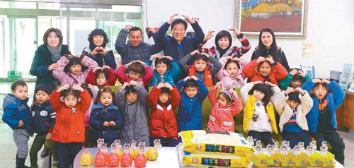 광주 광산구 라파엘어린이집 아이들이 24일 광산구 우산동 주민센터를 방문해 용돈을 모은 돼지저금통 23개를 전달하고 함께 기념사진을 찍고 있다. 광주 광산구 제공