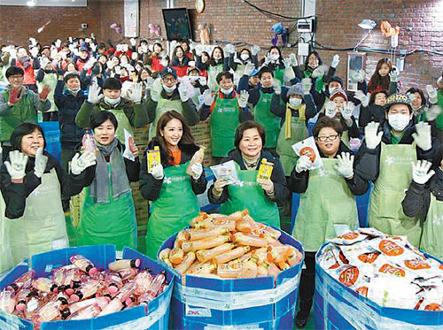 23일 서울 성동구 아름다운가게 서울그물코센터에서 아름다운가게 관계자와 자원봉사자들이 나눔 보따리 포장작업을 하면서 ‘아름다운 나눔 보따리’라고 적힌 흰 면장갑을 낀 채 두 손을 흔들고 있다. 아름다운가게 제공