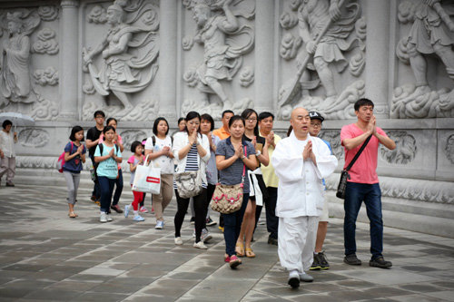 삼광사 주지 무원 스님(맨 앞에 흰 옷 입은 사람)이 꺋걷기 명상 프로그램꺍에 참여한 일반인들과 함께 합장하며 걷고 있다.